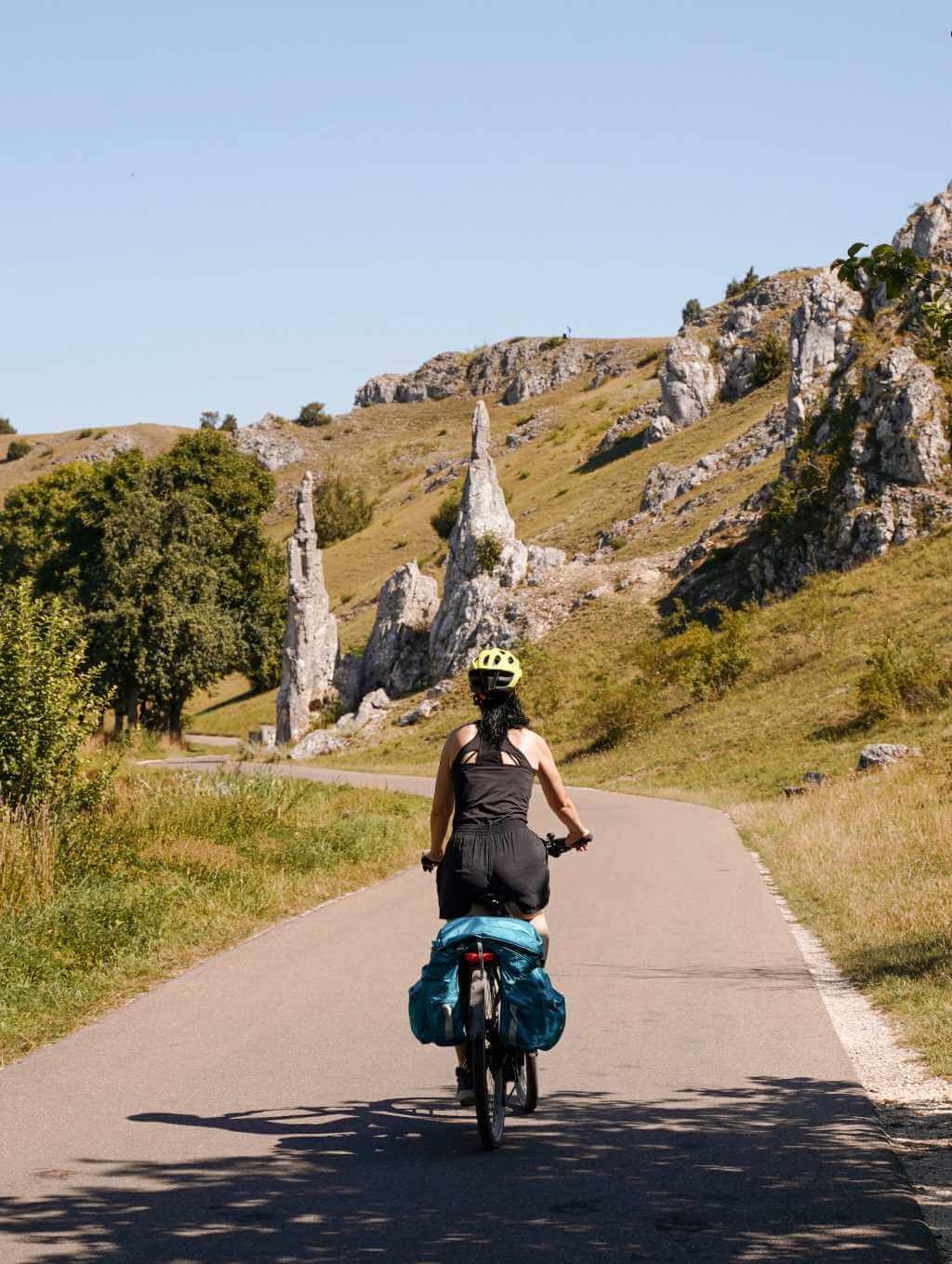 Fahrradfahrerin fährt im Eselsburger Tal auf die Felsformation der Steinernen Jungfrauen zu